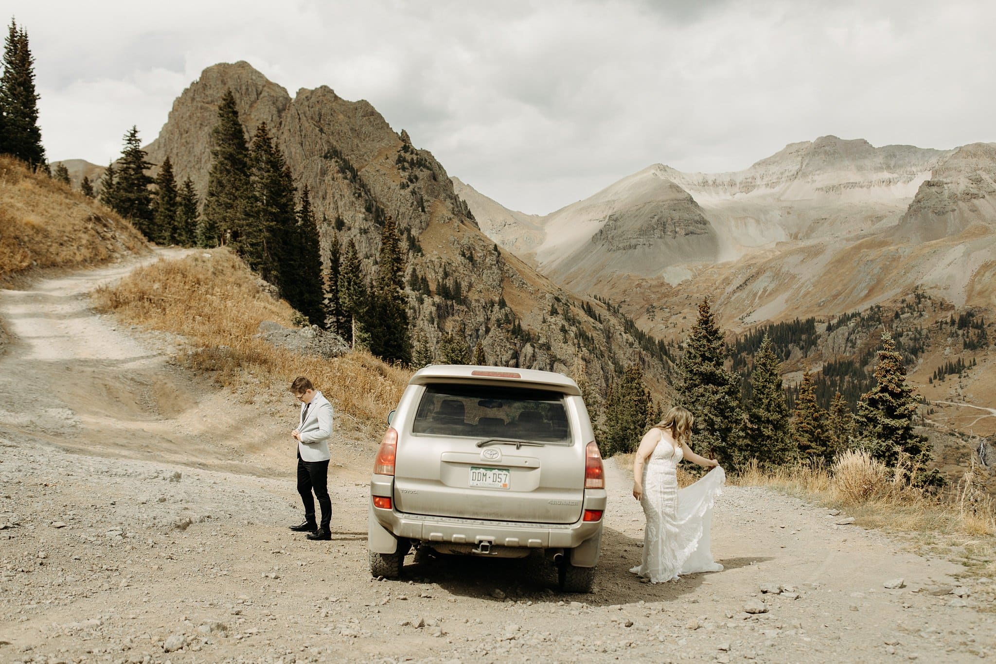 bride and groom getting ready on top of mountain in ouray