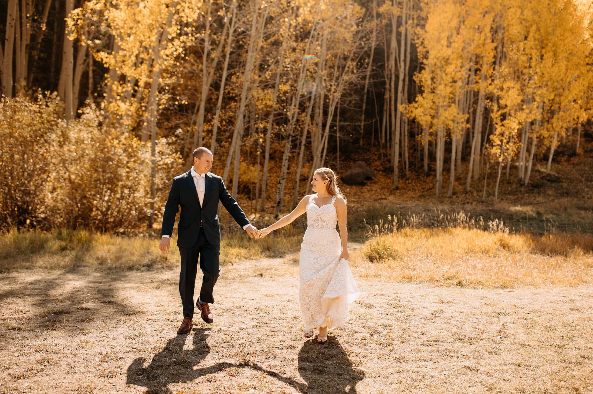 Kelly and Anthony planned a fall jeeping elopement in Telluride during the peak of fall so they could be surrounded by the gorgeous colors. A fun fact I like to tell visitors is that all Aspen trees are connected by an intricate root system making them one living organism. Creating the largest living organism on earth! I met Kelly and Anthony at the Cimarron Lodge, where they finished getting ready. Then, they slipped into their wedding attire for an official first look in the Aspens. A sweet tear-filled moment. We packed the jeep and drove to our first stop, Bridal Veil falls. Located at the end of the box canyon, we slowly made our way up to the base of the falls. We hiked around the waterfall for some epic pictures of Colorado's tallest free-falling waterfall. Then we hopped back into the jeep and drove further into the mountains for the ceremony. We found a quiet little Aspen grove in the mountains for their ceremony. Warm light shined through the tops of the trees as they read their vows. Afterward, they celebrated with local craft beers and an epic champagne toast. We ended the day by the lakeshore just as the stars started appearing in the sky. Kelly and Anthony's fall jeeping elopement in Telluride was the perfect day that focused on love and adventure! Jeep Rental: Cliffhanger You can view Kerry and Randy's Fall Elopement with Frozen Waterfalls in Telluride here!